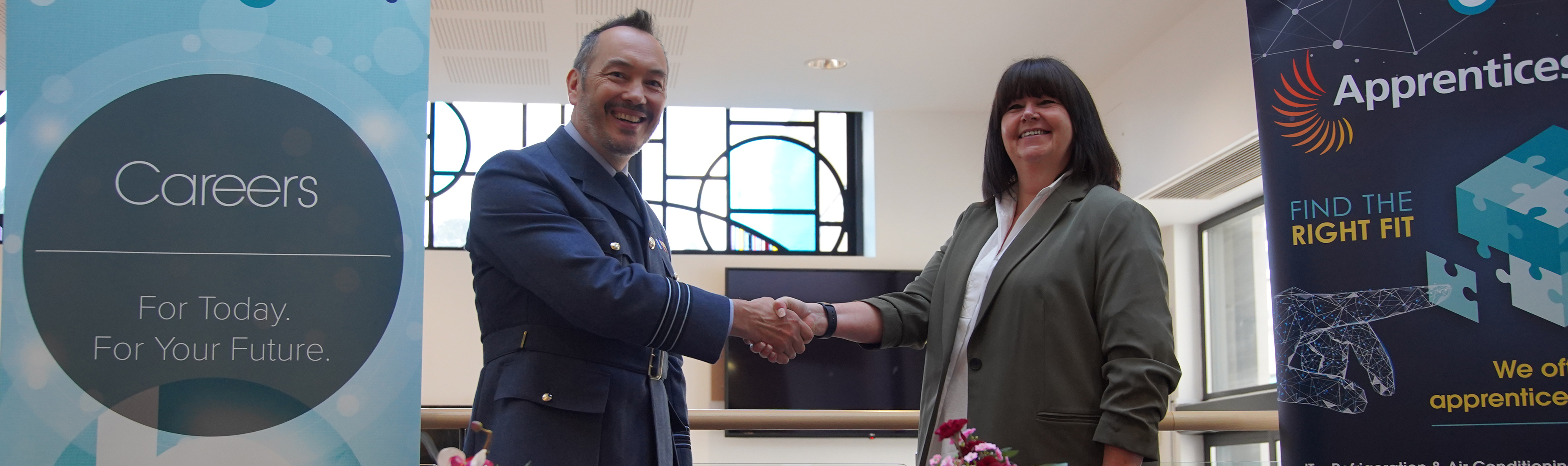 Principal & CEO Jayne Davis shakes hands with Wing Commander Alex Drake after signing the Armed Forces Covenant